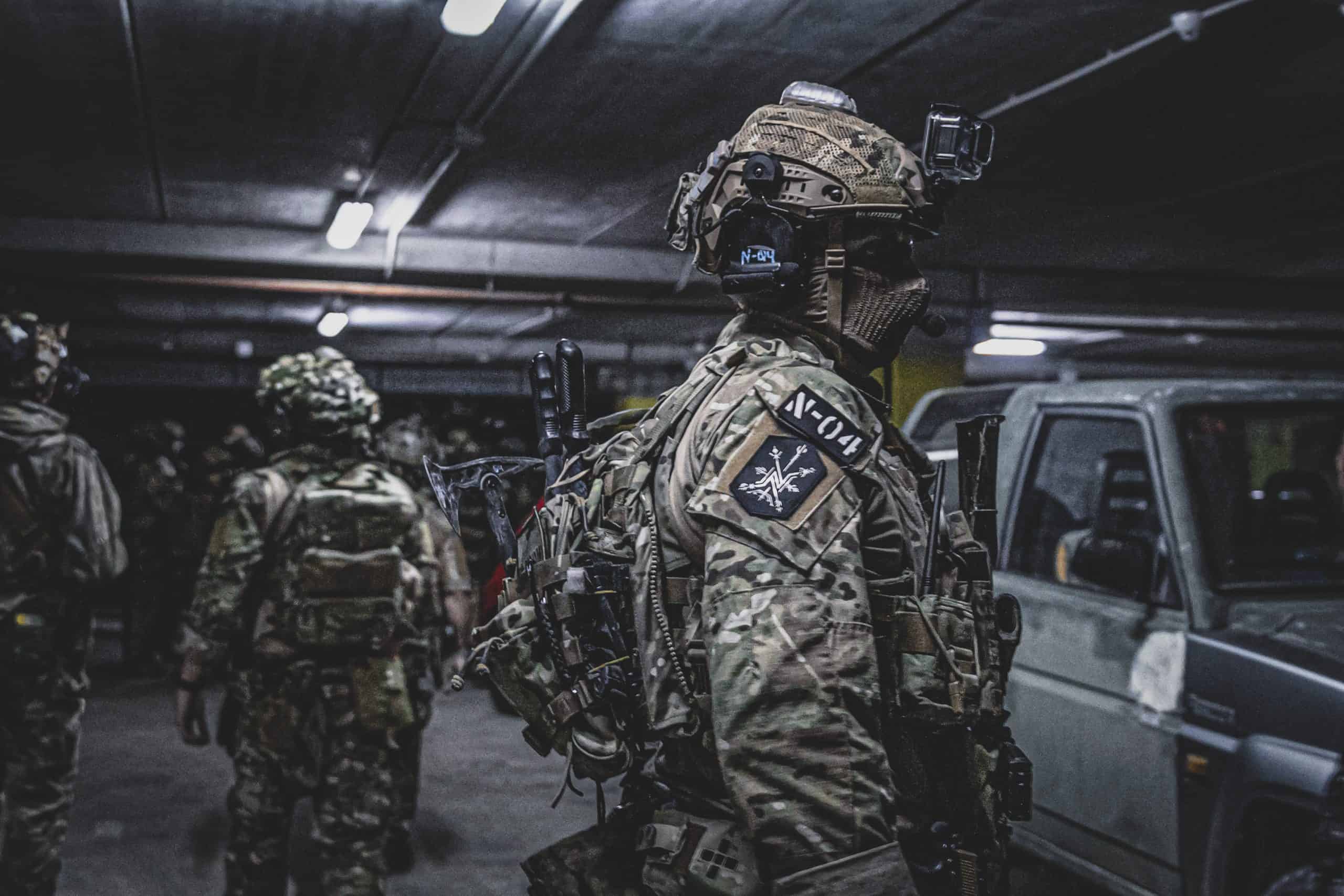 Dos jugadores avanzando por el interior de una nave industrial en una MILSIM