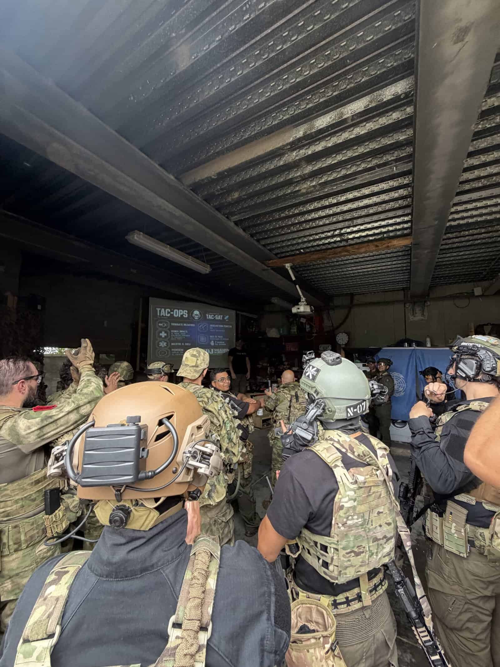 Briefing antes de una partida de airsoft con las normas del campo proyectadas