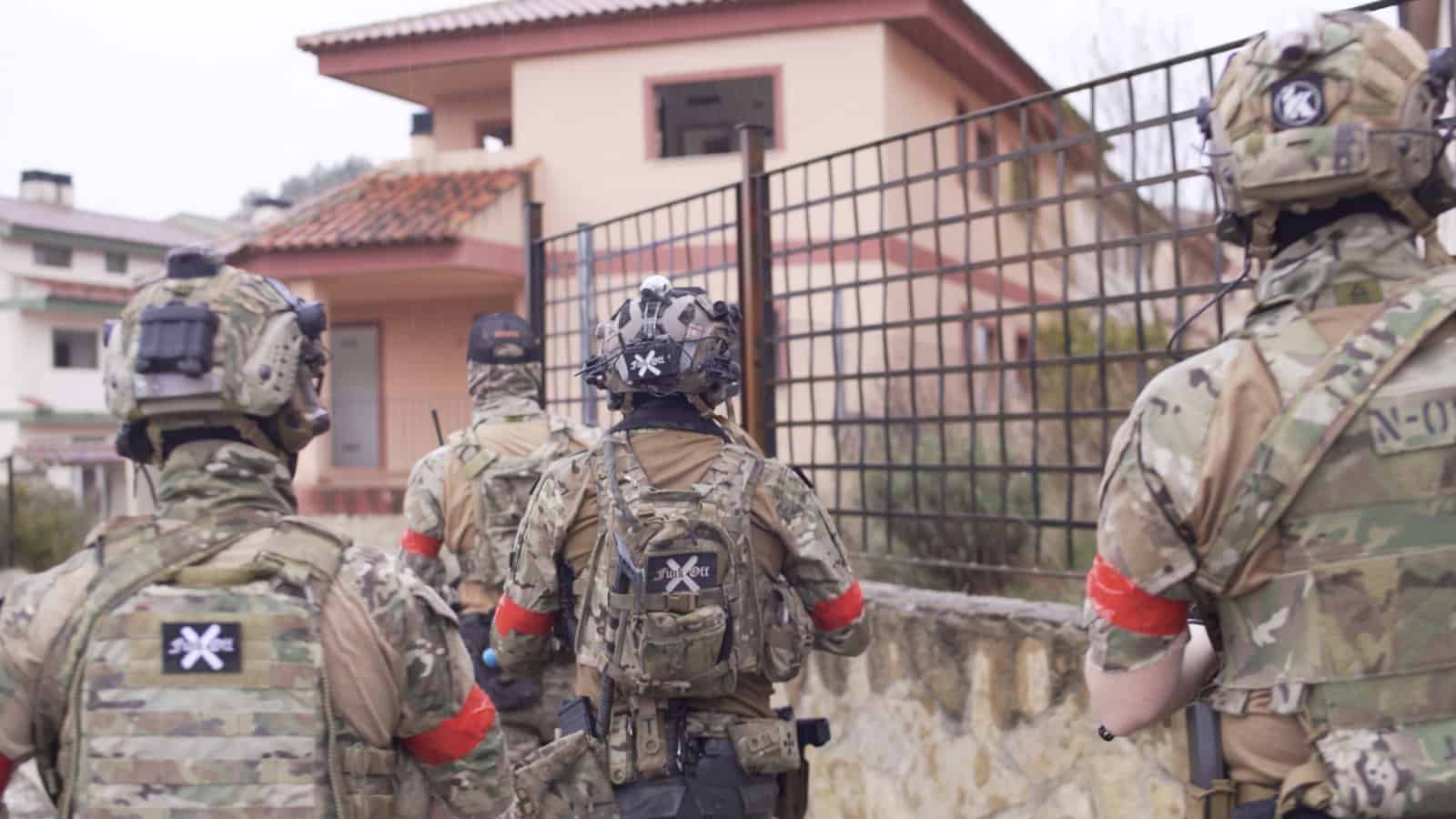Equipo de airsoft con brazaletes identificativos durante una partida