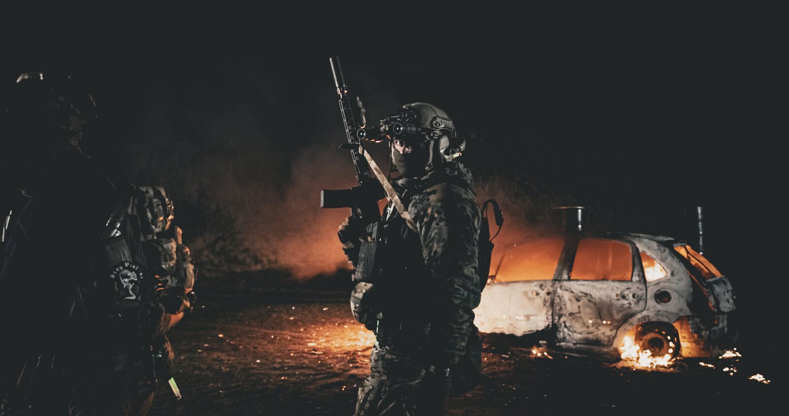 Dos jugadores de airsoft con ropa Brothers in Arms en una partida nocturna