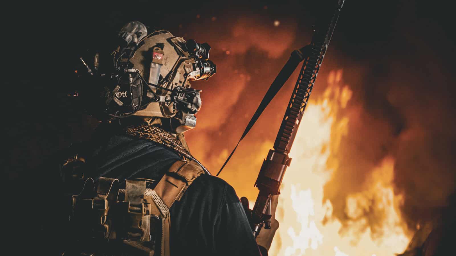 Jugador con visión nocturna y equipo Brothers in Arms delante de un vehículo ardiendo