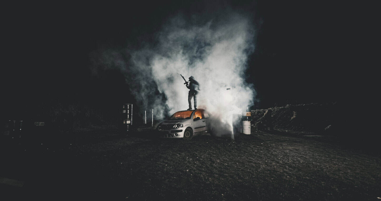 Escena nocturna con humo y un vehículo iluminado durante una sesión de Brothers in Arms