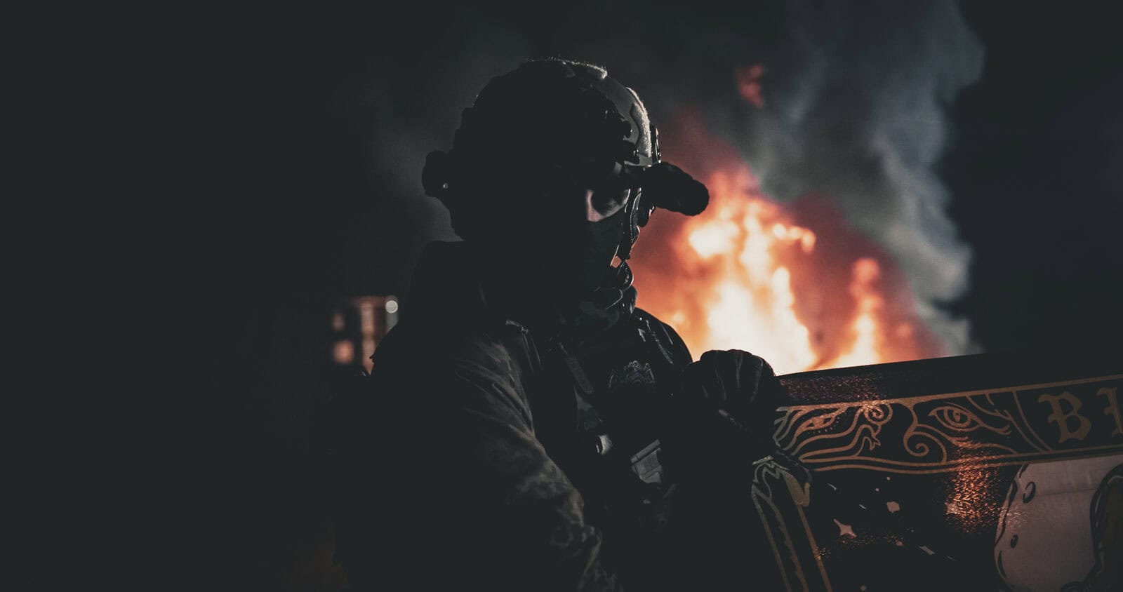 Silueta de un jugador con gorra Brothers in Arms delante del fuego