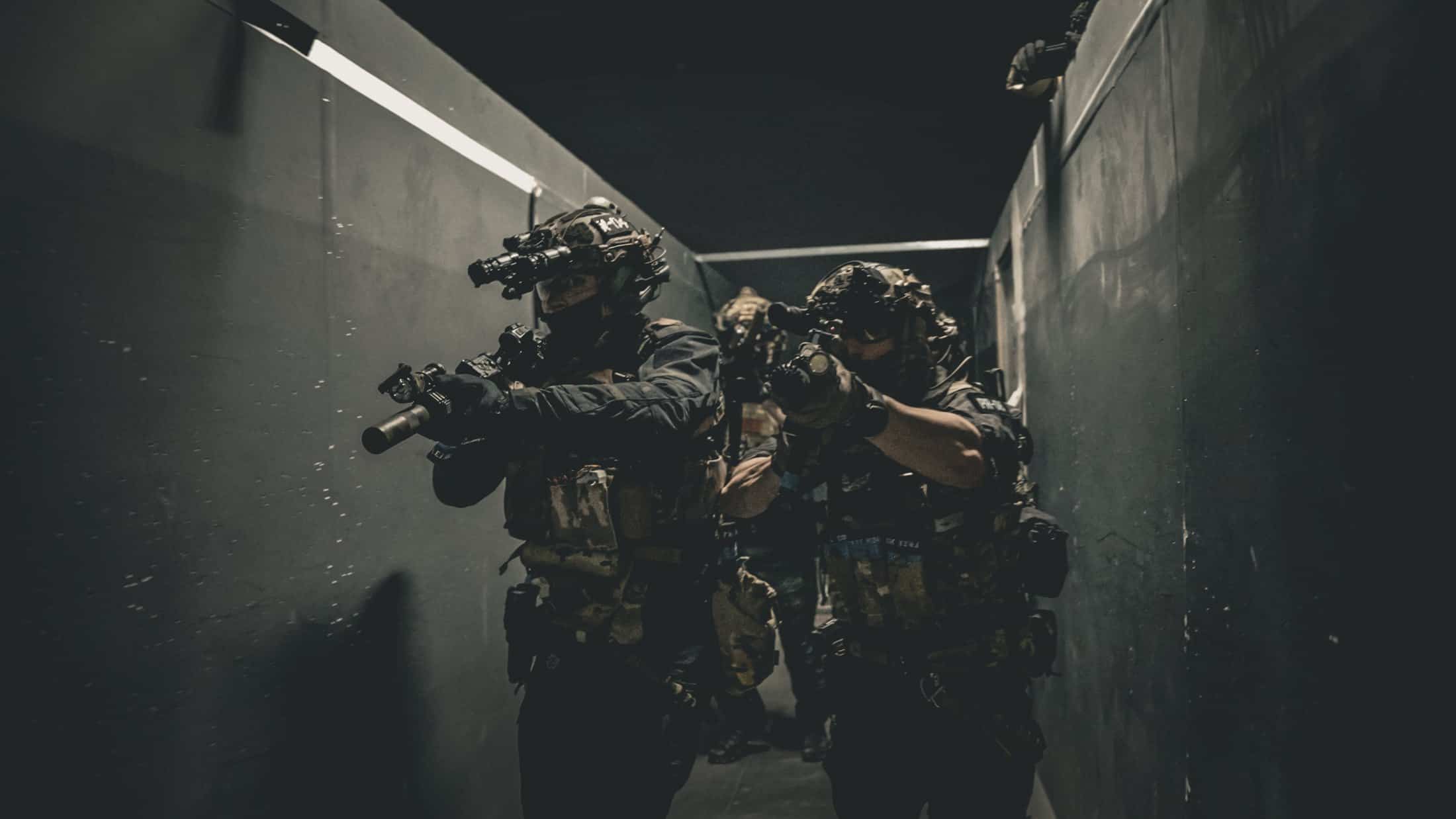 Jugadores de airsoft avanzando por un pasillo de un campo CQB de Madrid