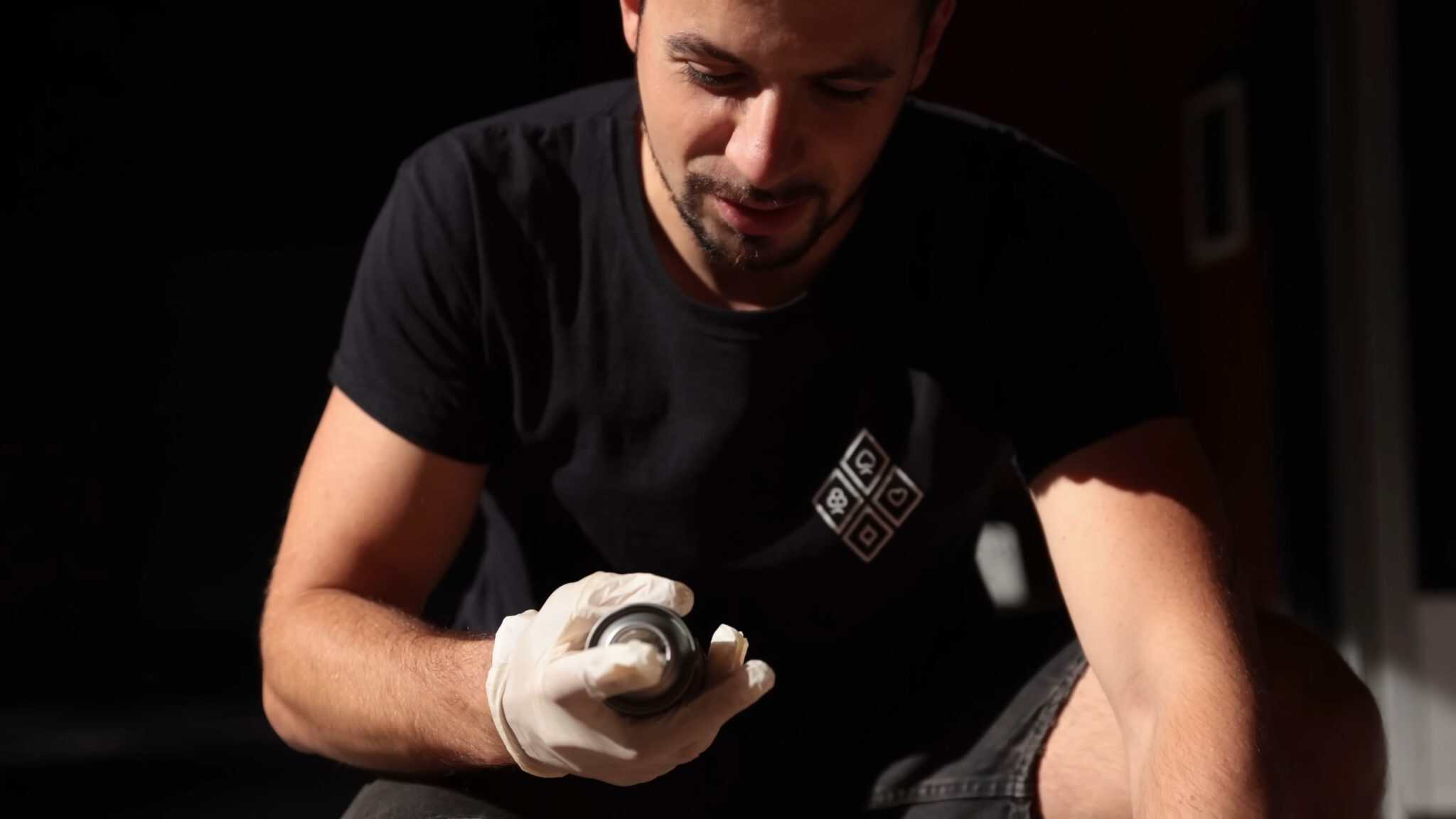 Aritz agitando el spray de pintura mate con guantes antes de pintar el casco de airsoft