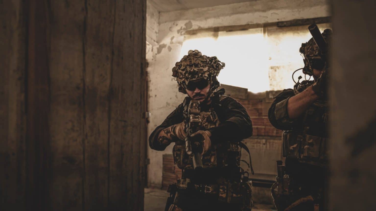Jugador apuntando al entrar por una puerta en un entrenamiento de CQB
