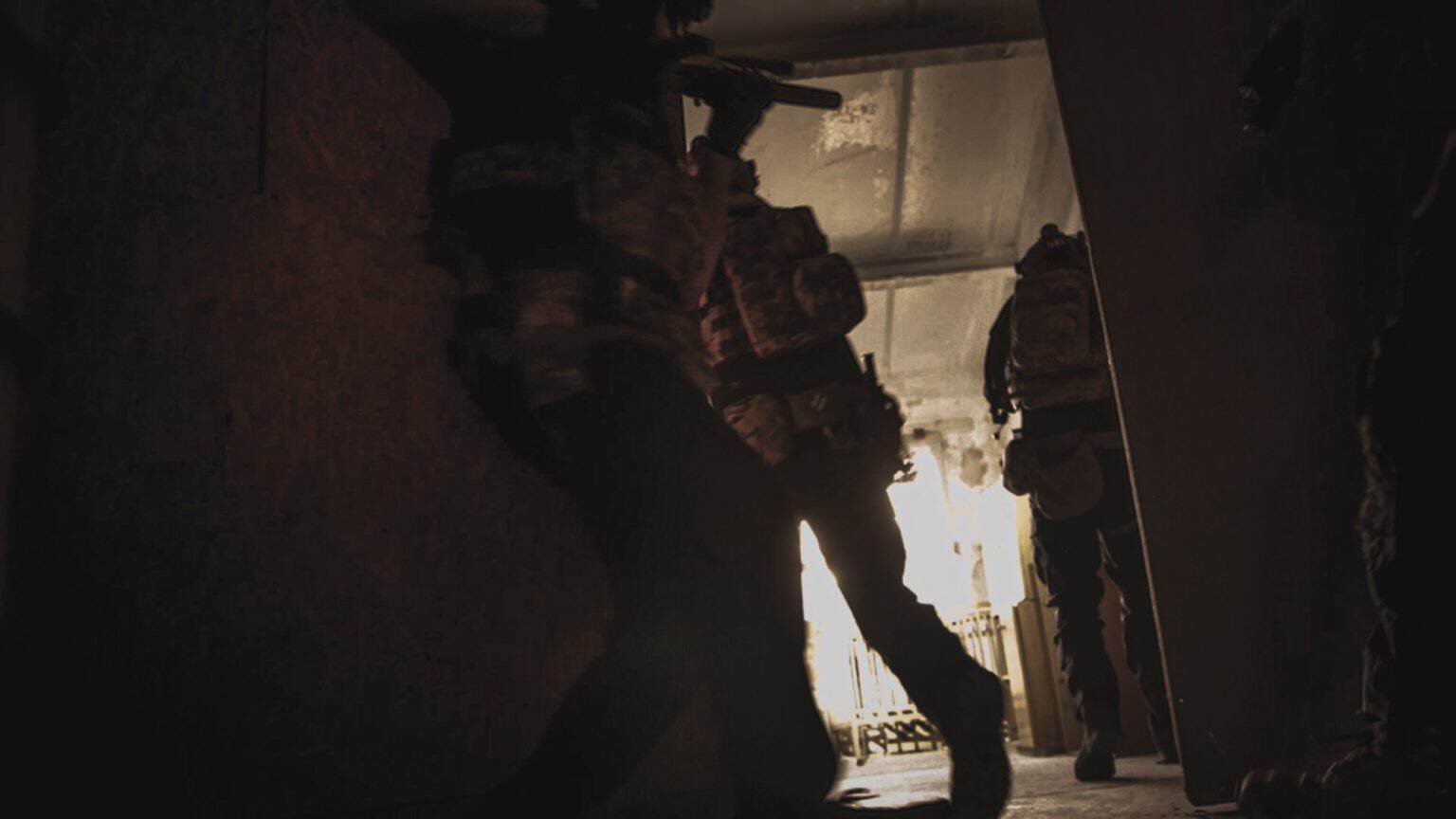 Equipo entrando a contraluz en un pasillo de CQB