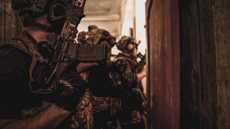 Equipo pegado a la puerta antes de entrar, con el cargador en primer plano
