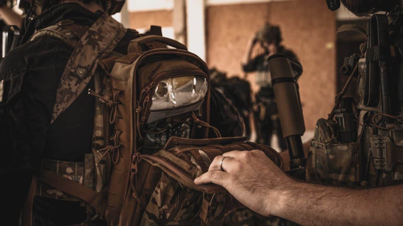 Abriendo el bolsillo de una mochila táctica con el botiquín