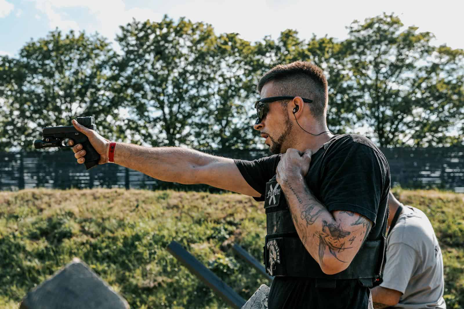 Tirador deportivo disparando una pistola en un campo de tiro, licencia de armas F