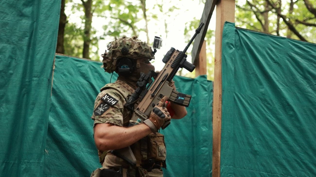 Jugador de airsoft con fusil SCAR y casco en una partida de CQB