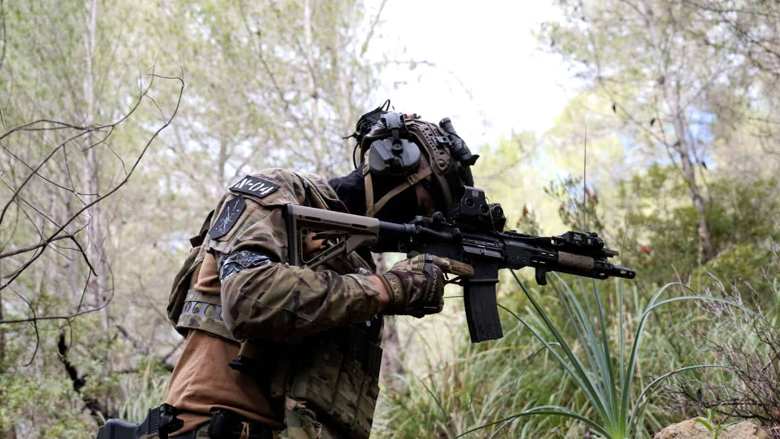 Jugador de airsoft apuntando en el monte